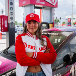 Fabianne Besosa, piloto puertorriqueña y embajadora de Texaco con Techron, posa junto a su auto de carreras