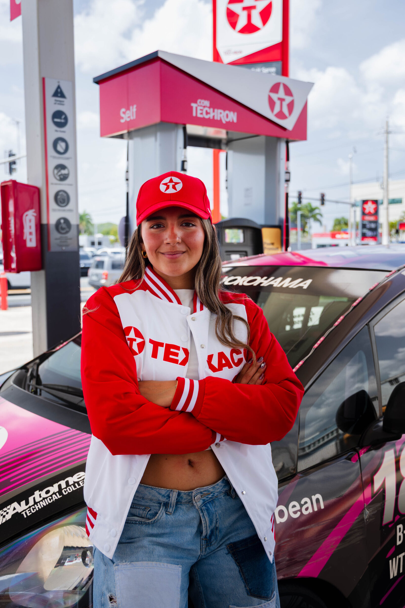 Fabianne Besosa, piloto puertorriqueña y embajadora de Texaco con Techron, posa junto a su auto de carreras